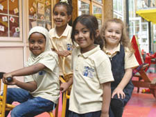 Sadia Sharif and Naomi Bereket, both five, Aneeka Subhan, four, and Amelia Tusha, five, celebrate the opening of the Brecknock School children's centre by newsreader Jon Snow