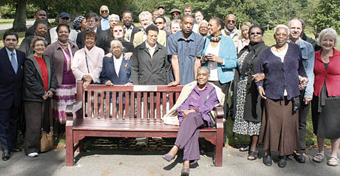 Corinne Carter sits at the Waterlow Park bench in memory of Trevor surrounded by friends and family