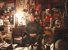 Redwood holds court in a straight-backed chair in front of his high altar - an antique chest of drawers with a Tibetan Buddharupa perched on top. 